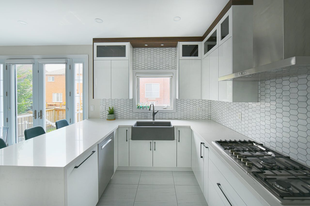 Bright and spacious modern kitchen featuring a large island, farmhouse sink, and sleek cabinetry.